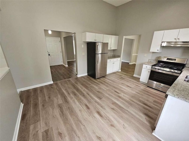 3763 Waldrop Hills Dr, Decatur, GA 30034 - kitchen featuring a high ceiling, light wood-style floors, stainless steel appliances, and under cabinet range hood