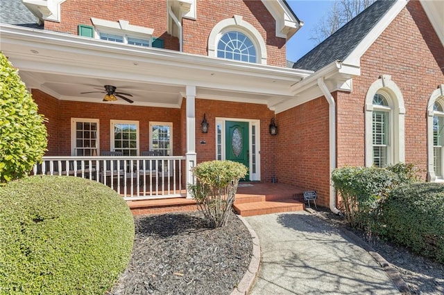 view of exterior entry featuring a porch and brick siding