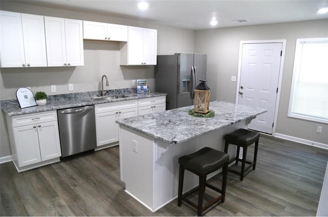 414 E 17th St E, Rome, GA 30161 - kitchen with stainless steel appliances, a sink, a breakfast bar area, a kitchen island, and white cabinetry