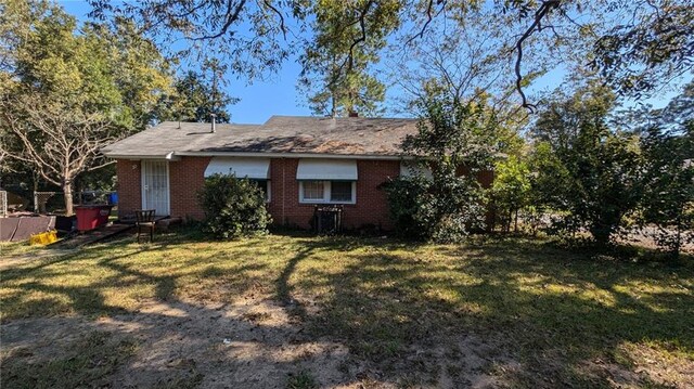 rear view of property featuring a lawn