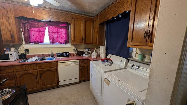 clothes washing area featuring ceiling fan, washing machine and dryer, and sink