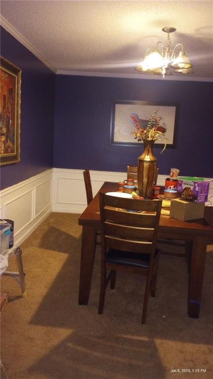 80 Place Fontaine, Lithonia, GA 30038 - dining room featuring a chandelier, ornamental molding, dark carpet, a wainscoted wall, and a decorative wall