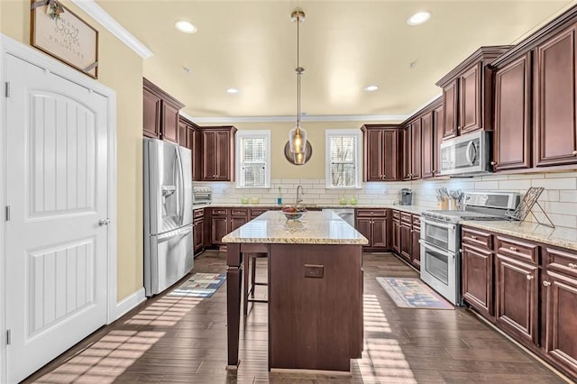 kitchen with stainless steel appliances, tasteful backsplash, a kitchen island, and dark wood finished floors