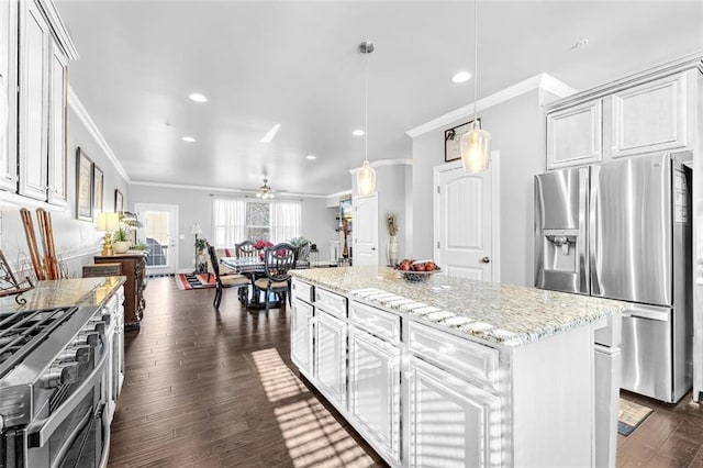 kitchen featuring a center island, dark wood finished floors, stainless steel appliances, ornamental molding, and light stone countertops