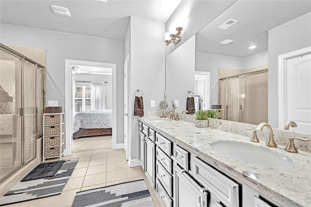 full bath with a stall shower, tile patterned flooring, visible vents, and a sink