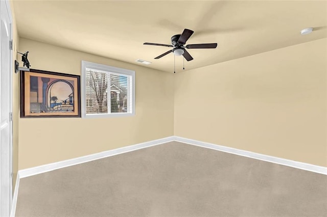 spare room featuring a ceiling fan, visible vents, and baseboards