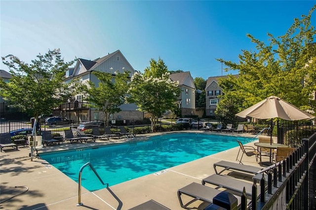 community pool with fence and a patio