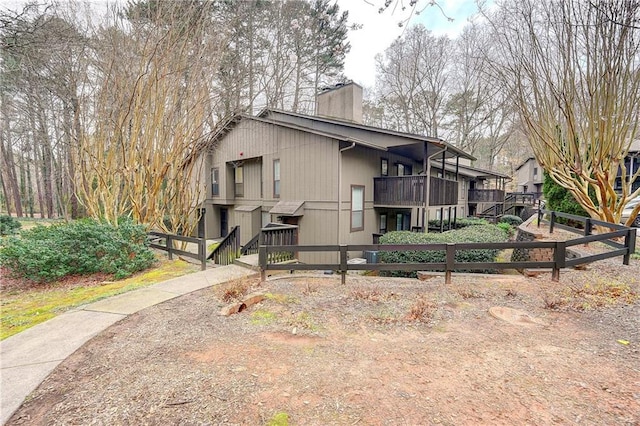 view of property exterior with a fenced front yard and a chimney