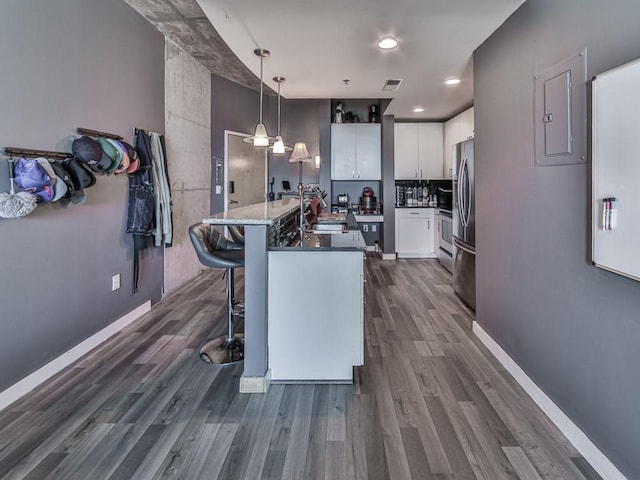 361 17th St NW Unit 1121, Atlanta, GA 30363 - kitchen with white cabinetry, a kitchen island with sink, sink, decorative light fixtures, and stainless steel fridge