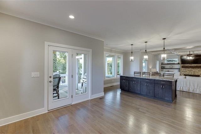 3441 Shoreland Dr, Buford, GA 30518 - kitchen with open floor plan, wood finished floors, a kitchen island, baseboards, and ornamental molding