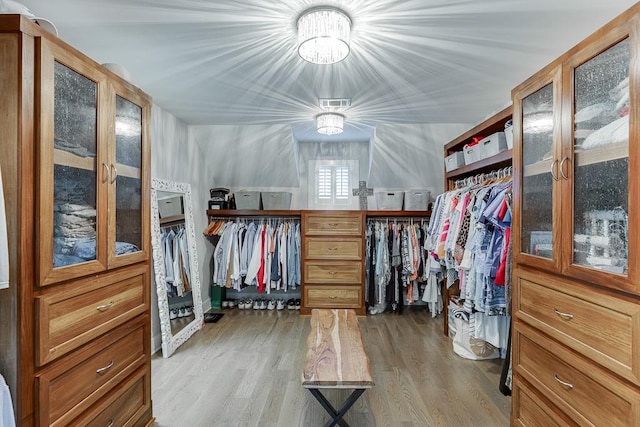 3441 Shoreland Dr, Buford, GA 30518 - walk in closet featuring light wood-style flooring and a chandelier