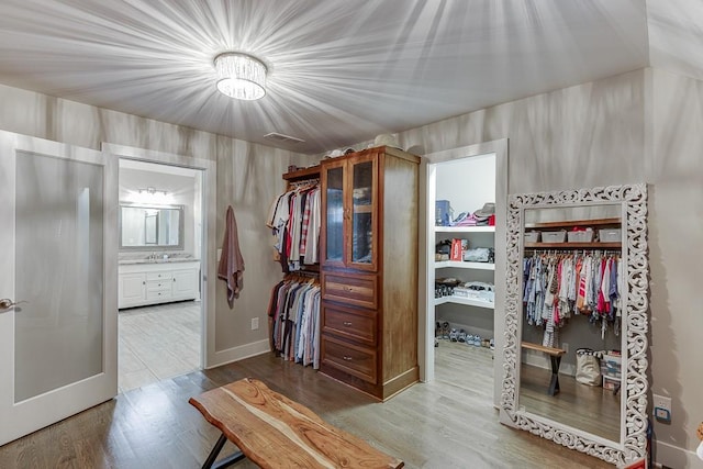 3441 Shoreland Dr, Buford, GA 30518 - spacious closet with wood finished floors, a sink, and a chandelier