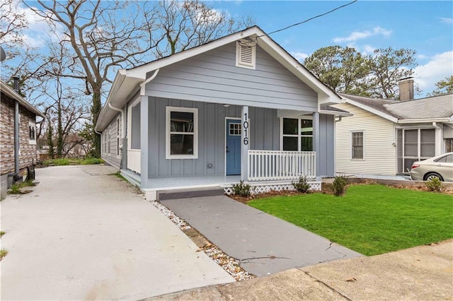 view of front of home with a porch and a front lawn