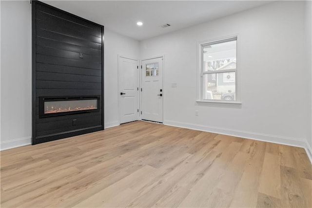 entrance foyer featuring a fireplace and light hardwood / wood-style floors