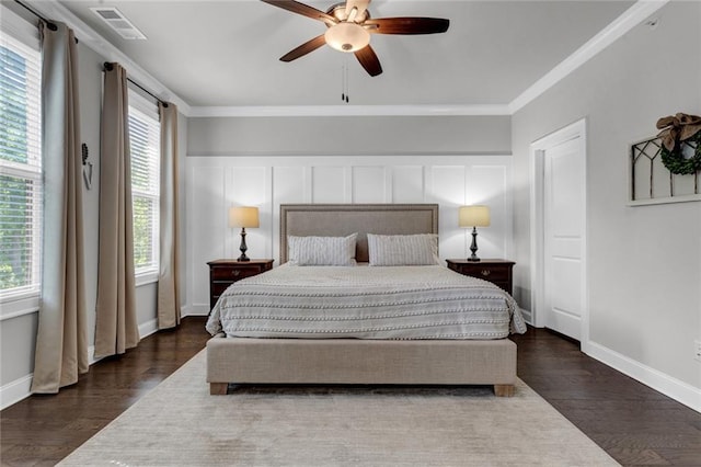 bedroom with dark hardwood / wood-style floors, ornamental molding, and ceiling fan