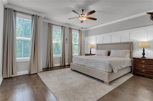 bedroom featuring dark hardwood / wood-style flooring, ceiling fan, and multiple windows