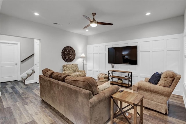 living room featuring ceiling fan and dark hardwood / wood-style floors