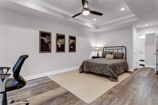 bedroom with a tray ceiling, ceiling fan, and wood-type flooring