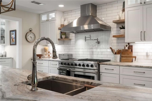kitchen with beverage cooler, stainless steel appliances, light stone counters, and island range hood