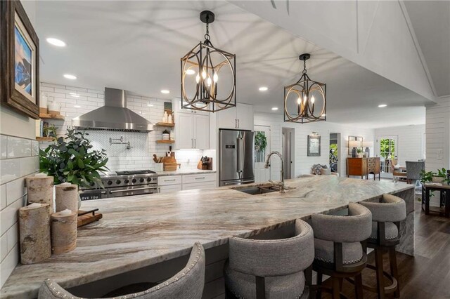 kitchen featuring open shelves, decorative backsplash, wall chimney exhaust hood, white cabinets, and range with two ovens
