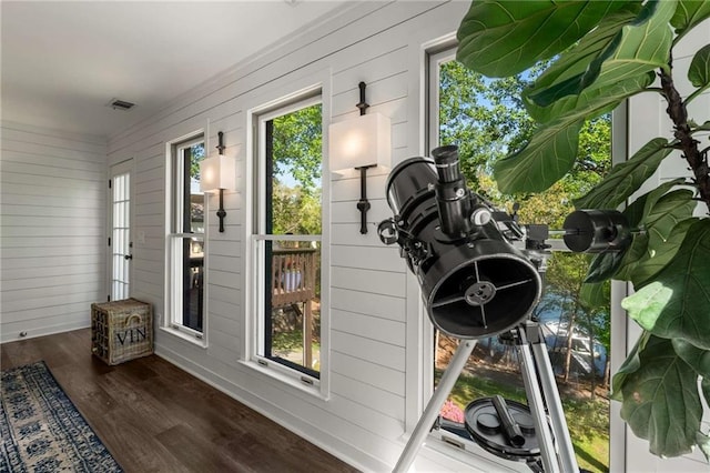 bedroom featuring a raised ceiling, ornamental molding, wood finished floors, and access to exterior