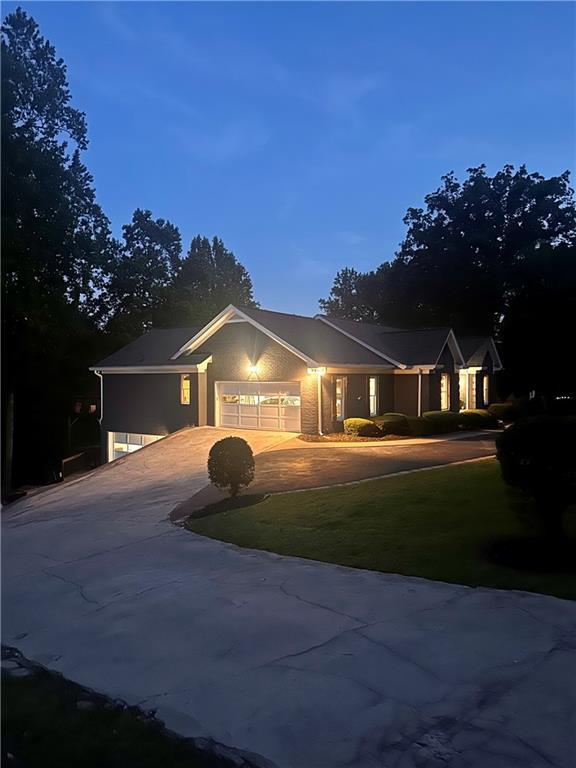 single story home featuring concrete driveway, a front lawn, and a garage