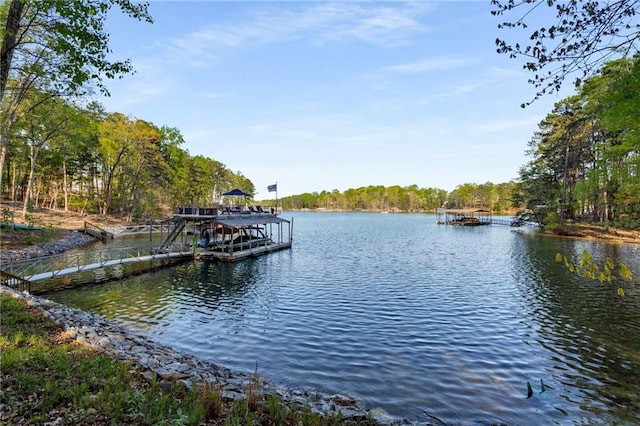 dock area with outdoor dining area and a water view