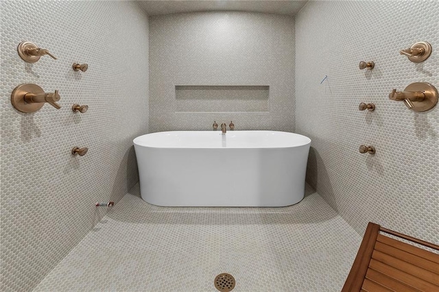 bathroom featuring tile patterned flooring and a tub to relax in