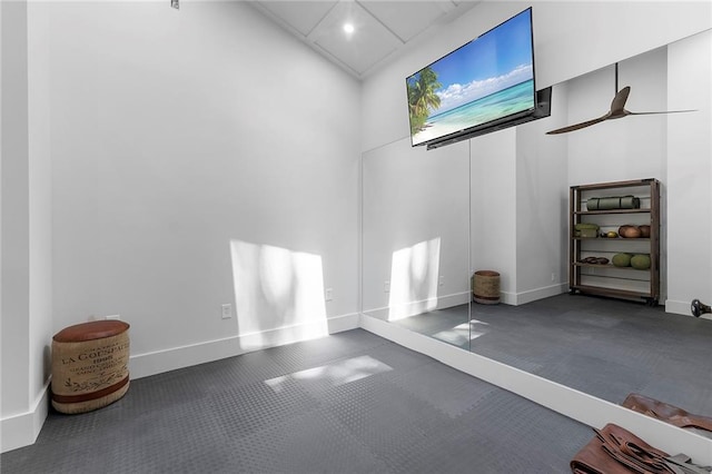 exercise area with a high ceiling and ceiling fan