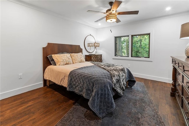 bedroom featuring ornamental molding, dark wood-type flooring, and ceiling fan