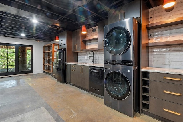 laundry area featuring stacked washer / dryer and sink