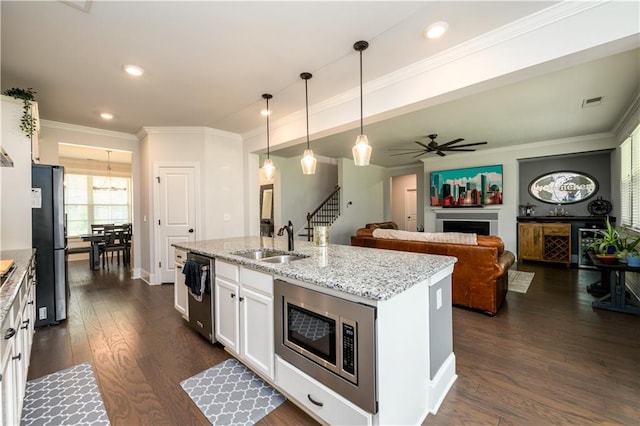 kitchen featuring stainless steel appliances, a sink, white cabinetry, dark wood finished floors, and a ceiling fan