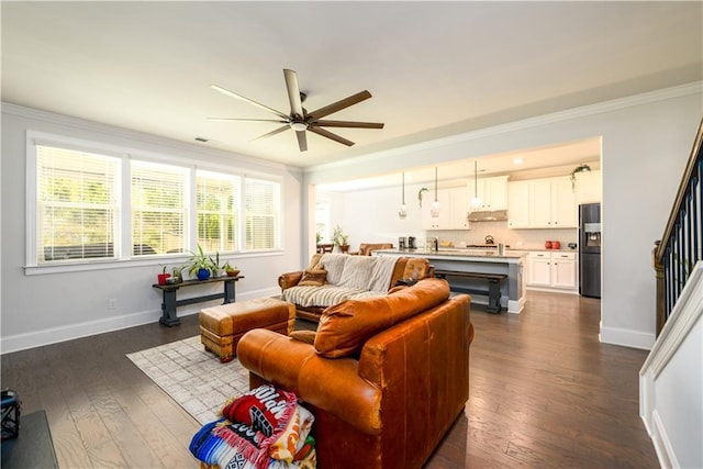 living room with ceiling fan, ornamental molding, dark wood-style floors, and baseboards