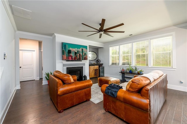 living room featuring ceiling fan, baseboards, crown molding, wood finished floors, and a glass covered fireplace