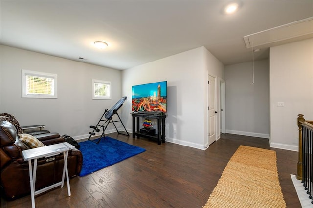 exercise area featuring attic access, wood finished floors, and baseboards