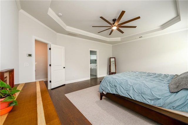 bedroom with a tray ceiling, dark wood-style flooring, crown molding, ceiling fan, and baseboards