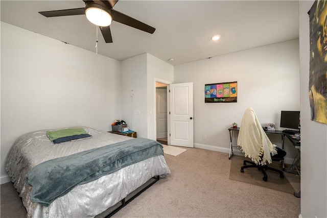 carpeted bedroom featuring ceiling fan, an office area, and baseboards
