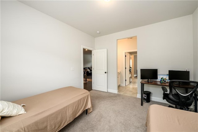 bedroom featuring light colored carpet, an office area, and baseboards