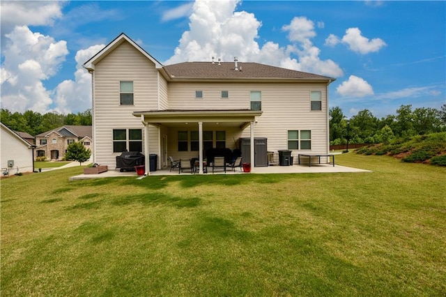 rear view of house with a patio and a lawn