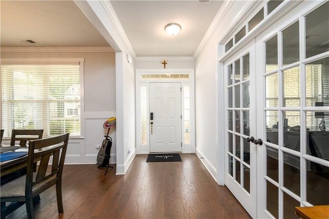 foyer featuring french doors, dark wood-style flooring, ornamental molding, and wainscoting