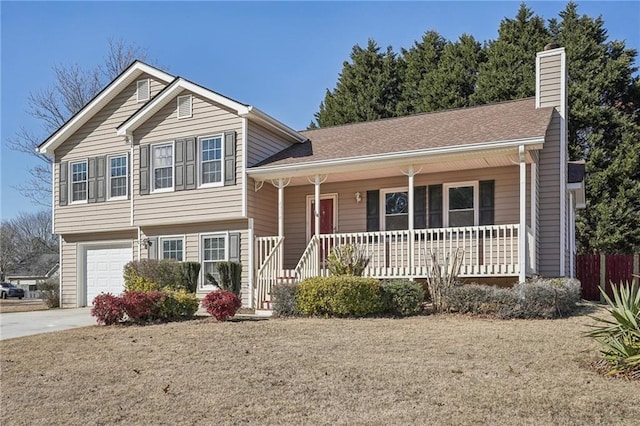 split level home featuring a porch, a garage, and a front yard