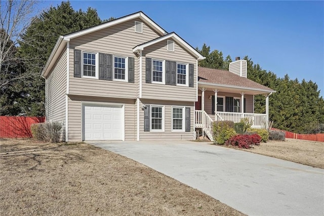 tri-level home featuring a garage, a front yard, and covered porch