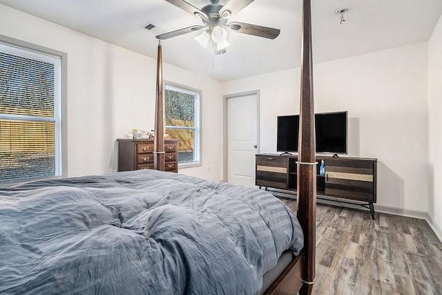 bedroom featuring ceiling fan, baseboards, and wood finished floors