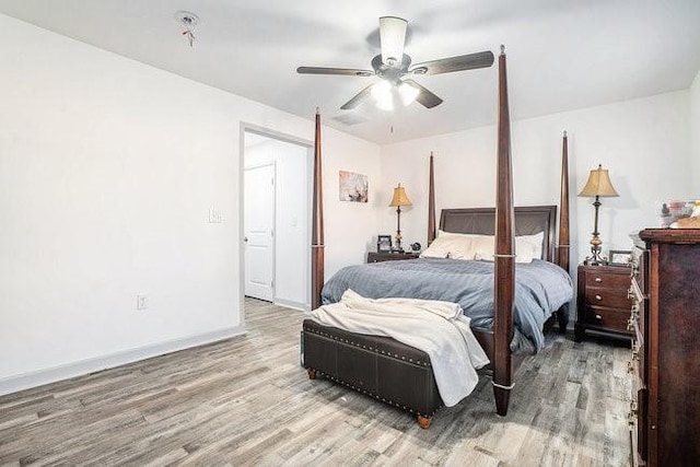 bedroom featuring light wood finished floors, a ceiling fan, and baseboards