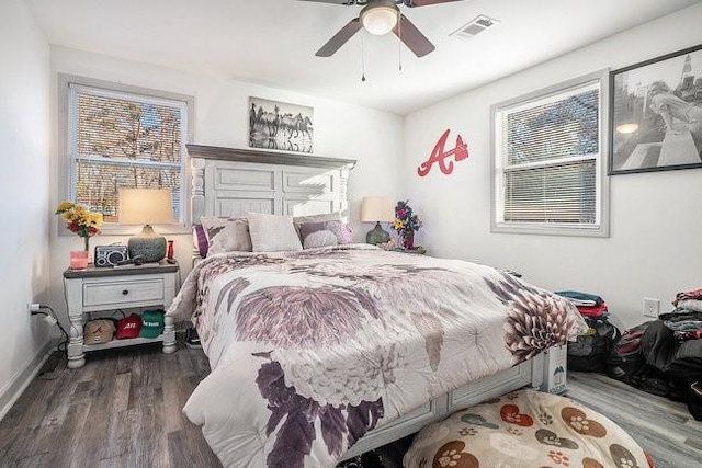 bedroom with ceiling fan, multiple windows, wood finished floors, and visible vents