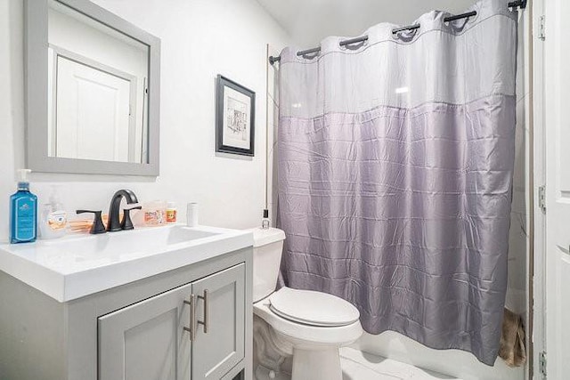 full bathroom featuring curtained shower, vanity, and toilet