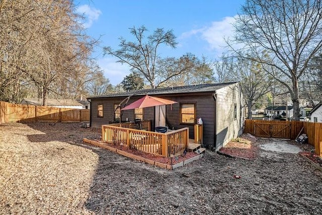 rear view of property with a deck and a fenced backyard