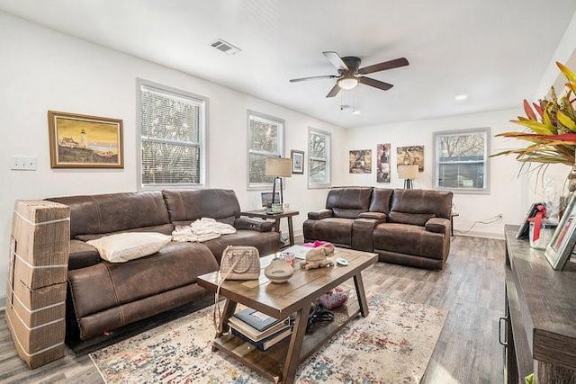 living area with light wood-style floors, visible vents, and a ceiling fan