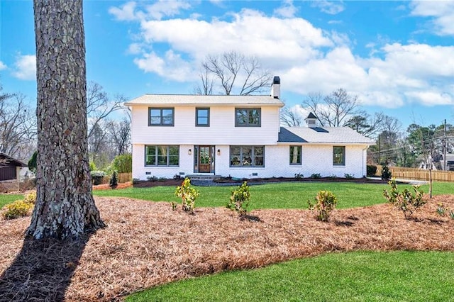 colonial inspired home with crawl space, a front lawn, a chimney, and brick siding