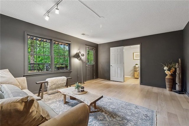 2986 Edenberry Ln NW, Kennesaw, GA 30152 - living room with a textured ceiling, light wood-style floors, baseboards, and track lighting